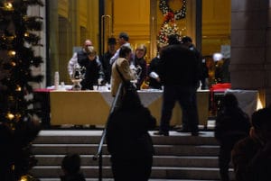 people at a vendor's table during an evening festifal